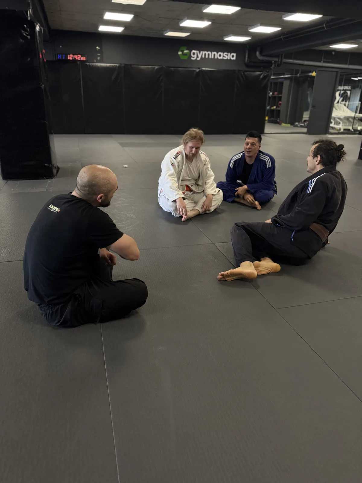 Participants du camp — Archive photo of a coach talking through a technique with students in gi
